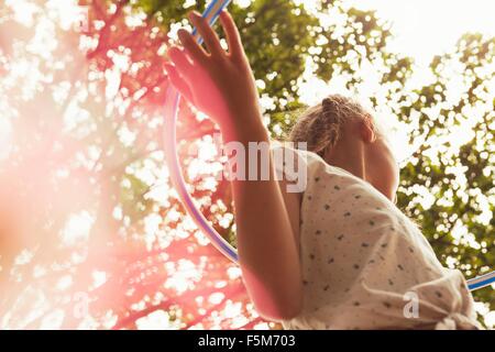 Niedrigen Winkel Blick auf Mädchen spielen mit Hula Hoop wegschauen Stockfoto