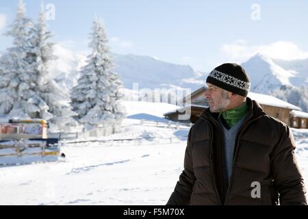 Taille bis senior woman und tief verschneiten Bäumen wegsehen, Sattelbergalm, Tirol, Österreich Stockfoto