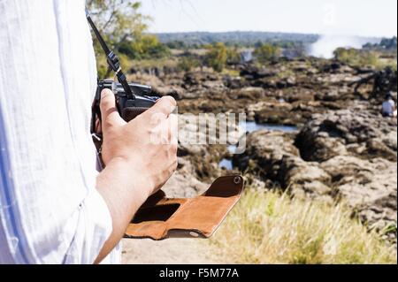Schuss der Mann mit der Kamera in der Nähe von Victoria Falls, Sambia beschnitten