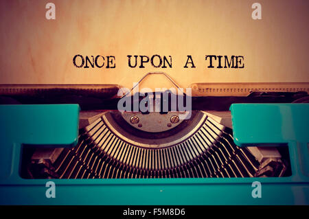 Nahaufnahme von einer blauen Retro-Schreibmaschine und einmal mit ihm in eine gelbliche Folie geschriebener text Stockfoto