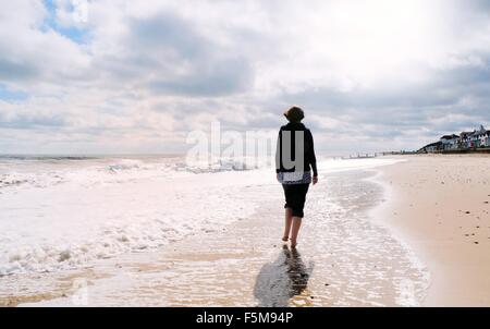 Reife Frau, Strand entlang, Rückansicht Stockfoto