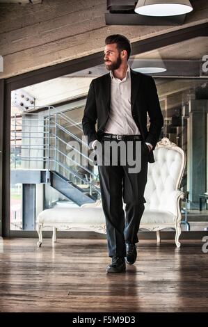 Voller Länge Vorderansicht der Mitte erwachsener Mann Anzug Hände in den Taschen wegschauen Stockfoto