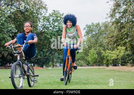 Vorderansicht von Mutter und Sohn Reiten auf Fahrrädern lächelnd Stockfoto