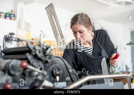 Druckerin Vorbereitung Druckmaschine in Werkstatt Stockfoto