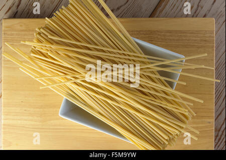 Ungekochten Linguine Nudeln ruht auf einer weißen Schüssel. Stockfoto