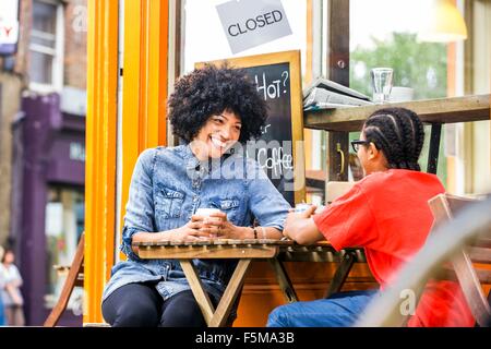 Junge und Mutter im Chat im Straßencafé Stockfoto