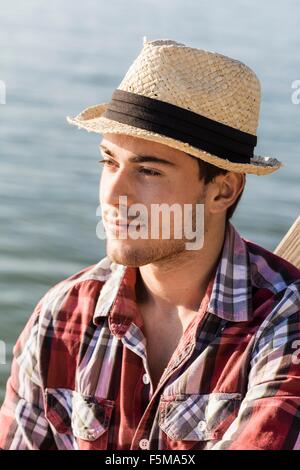 Porträt des jungen Mann mit Strohhut wegschauen Stockfoto
