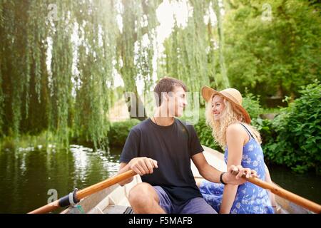 Romantische junges Paar im Ruderboot auf ländlichen Fluss Stockfoto