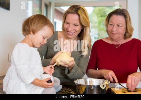 Großmutter, Tochter und Kleinkind Enkelin Teig in Küche vorbereiten Stockfoto
