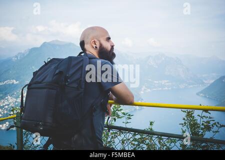 Mitte erwachsenen Mannes auf Balkon mit Blick auf den Luganer See, Schweiz Stockfoto