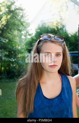 Porträt von Teenager-Mädchen mit langen braunen Haaren im Garten Stockfoto