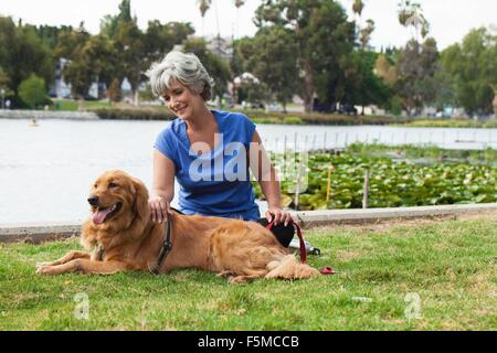 Reife Frau mit Hund im Park sitzend Stockfoto