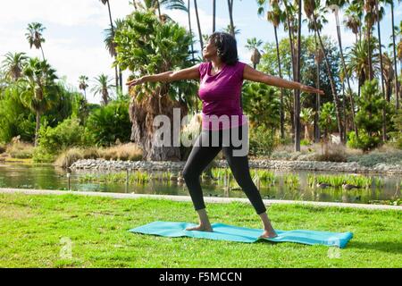 Ältere Frau beim Yoga im park Stockfoto