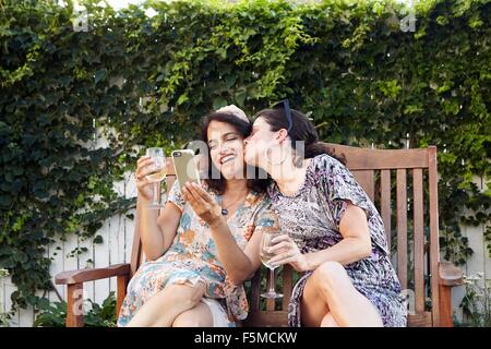 Zwei Frauen posieren für Smartphone Selfie auf Terrasse Stockfoto