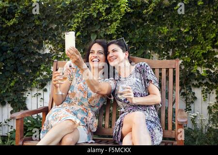 Zwei Frauen, die für Smartphone Selfie auf Terrasse Stockfoto