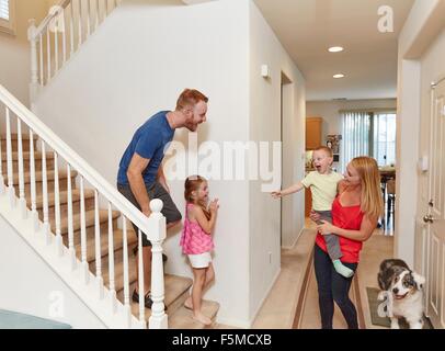 Familie auf Treppe zu Hause spielen Peek-a-boo Stockfoto