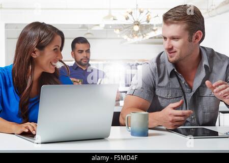 Zwei Kollegen haben Diskussion am Schreibtisch Stockfoto