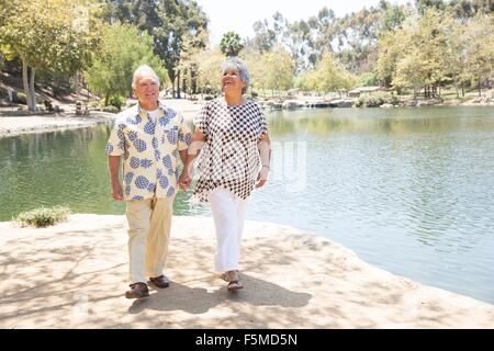 Älteres paar hand in hand gehen, am See Stockfoto