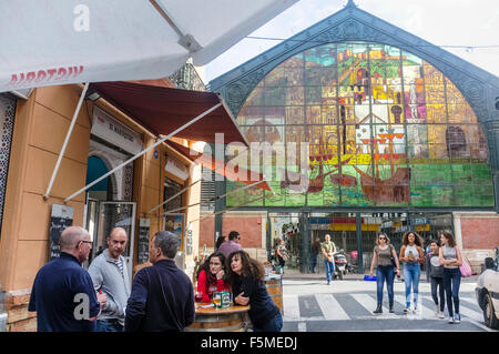 Spanier in einer Bar neben dem Eingang Buntglasfenster der Atarazanas Markt in Malaga, Andalusien, Spanien Stockfoto