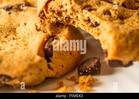 Eine Nahaufnahme der beiden Cookies auf einem weißen Teller mit einem haben eine Kleinigkeit mit Krümel aus ihm heraus genommen. Stockfoto