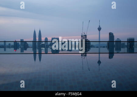 Skyline von Kuala Lumpur bei Sonnenaufgang mit einem Luxus-Pool im Vordergrund Stockfoto