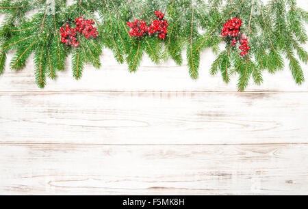 Weihnachtsbaum Zweig mit roten Beeren und Schneefall. Winter Urlaub Dekoration Stockfoto