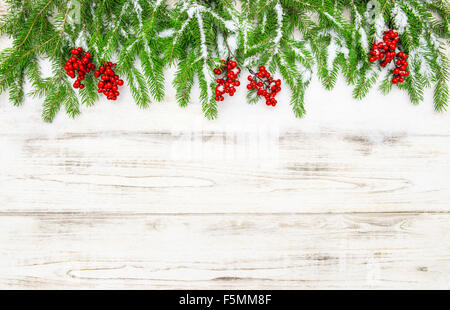 Weihnachts-Dekoration. Immergrüner Baum mit roten Beeren auf hölzernen Hintergrund. Leuchtende Farben Stockfoto