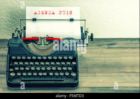 Schreibmaschine mit weißem Papierseite auf Holztisch. Beispieltext für die AGENDA 2016. Vintage-Stil getönten Bild Stockfoto