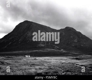 14. November 2005; Glen Coe, Schottland; Kleine Hütte unterhalb des Berges Buachaille Etive Mor. Glen Coe ist ein Tal in den Highlands von Schottland. Es liegt im südlichen Teil des Gebiets Lochaber Highland Council Area und gilt als Teil der traditionellen Grafschaft Argyll. Es wird oft als eines der spektakulärsten und schönsten Orte in Schottland und ist ein Teil der ausgewiesenen National Scenic Area von Ben Nevis und Glen Coe. Der Name Glen Coe wird im Volksmund, aber irrtümlich, angenommen, dass bedeutet die "Glen des Weinens", die möglicherweise aufgrund der steilen Berge, die drückend über Turm der Stockfoto