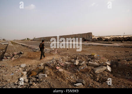 Ein kurdischer Kämpfer geht durch Schutt, der durch heftige Kämpfe verursacht wird Zwischen IS-Aktivisten und kurdischen Kämpfern in Rabia am Grenzübergang Zwischen Syrien und dem Irak in der Nähe der Stadt Al-Yarubiyah in Syrien Stockfoto