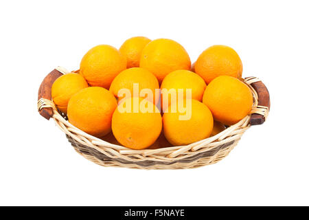 Orangen in einem Lebensmittel-Weidenkorb isoliert auf weißem Hintergrund Stockfoto