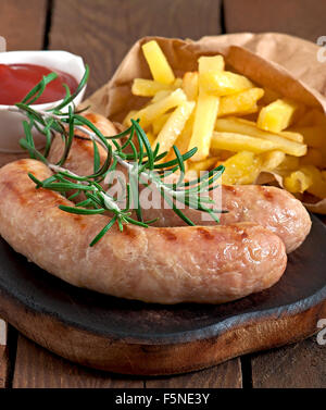 Hühnchen Würstchen gegrillt mit Pommes frites als Beilage Stockfoto