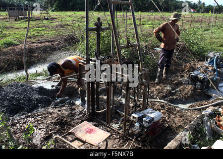Sumatra, Indonesien. 7. November 2015. Arbeiter Bohren für Rohöl zu Benzin in das Dorf Telaga Said, Langkat, Nord-Sumatra, Indonesien am 7. November 2015 verarbeitet werden. Gewinnung von Erdöl in dem, was ist bekannt als die ewige Ölfelder mit traditionellen Methoden und einfache Ausstattung. Die Lage des Öls, der Rest der niederländischen Kolonialzeit befindet sich in Palmöl-Plantagen ist einer der größten Öl behält sich in Indonesien mit dem End Ergebnis Kerosin und Diesel. Bildnachweis: Ivan Damanik/Alamy Live-Nachrichten Stockfoto