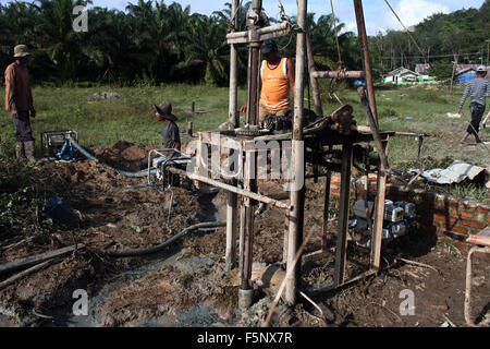 Sumatra, Indonesien. 7. November 2015. Arbeiter Bohren Rohöl zu Benzin in das Dorf Telaga Said, Langkat, Nord-Sumatra, Indonesien am 7. November 2015 verarbeitet werden. Gewinnung von Erdöl in dem, was ist bekannt als die ewige Ölfelder mit traditionellen Methoden und einfache Ausstattung. Die Lage des Öls, der Rest der niederländischen Kolonialzeit befindet sich in Palmöl-Plantagen ist einer der größten Öl behält sich in Indonesien mit dem End Ergebnis Kerosin und Diesel. Bildnachweis: Ivan Damanik/Alamy Live-Nachrichten Stockfoto