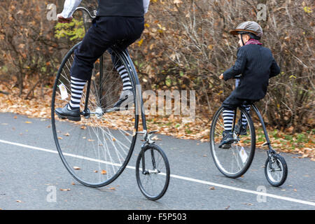 Traditionelles Penny Farthing Fahrradrennen. Mann und Kind Prag Letna Park Tschechische Republik Kinderfahrt mit historischem Fahrrad Stockfoto