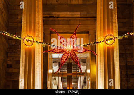 Weihnachtsstern geformt Weihnachten Licht Dekoration in der Tür eines Geschäftshauses hängt. Stockfoto