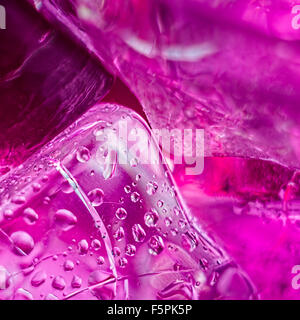 Eiswürfel mit Tropfen auf einem rosa Hintergrund Stockfoto