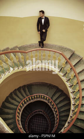 Schöner eleganter Mann stehend auf die altmodische Treppe Stockfoto