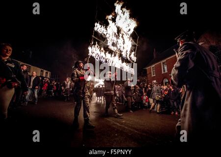 East Hoathly, UK. 7. November 2015. Lagerfeuer-Prozession zur Erinnerung. Tausende von Zuschauern Linie der Straßen von den winzigen East Sussex Dorf von East Hoathly in der Nähe von Lewes, Uhr Feuer Banner in Flammen als einen Akt der Erinnerung auf dem Weg in eine riesige Holzskulptur Lagerfeuer und Feuerwerk Anzeige durchgeführt. Bildnachweis: Jim Holden/Alamy Live-Nachrichten Stockfoto