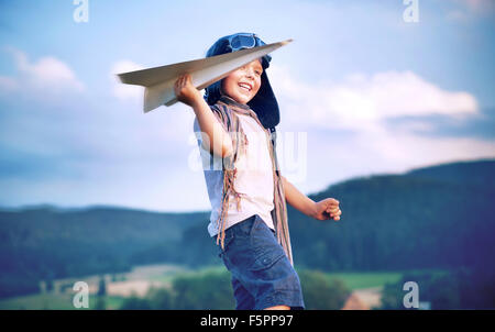 Fröhliche kleine Jungen Spielzeug Papierflieger Stockfoto