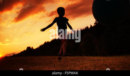 Kleines Kind Ballspiele auf dem Feld Stockfoto