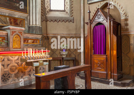 Hölzernen Beichtstuhl und Altar mit Kerzen in der Kathedrale von San Lorenzo in Alba, Italien. Stockfoto