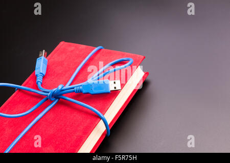 Blaues Band vom USB-Kabel auf das Buch Stockfoto