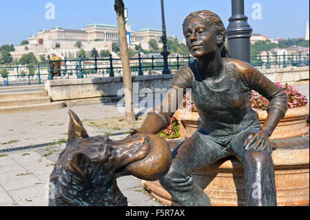 Eine Bronzeskulptur von ein Mädchen und ein Hund mit einem Ball in Budapest, Ungarn. Stockfoto