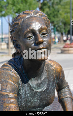 Eine Bronzeskulptur von ein Mädchen und ein Hund mit einem Ball in Budapest, Ungarn. Stockfoto