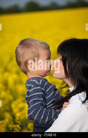 Kleiner Junge lachen gibt einen Kuss mit seiner Mutter. Stockfoto