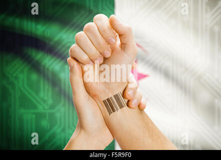 Barcode-ID-Nummer am Handgelenk einer menschlichen und nationale Flagge auf Hintergrund - Algerien Stockfoto