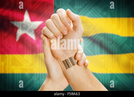 Barcode-ID-Nummer am Handgelenk einer menschlichen und nationale Flagge auf Hintergrund - Togo Stockfoto