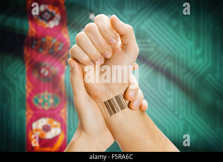 Barcode-ID-Nummer am Handgelenk einer menschlichen und nationale Flagge auf Hintergrund - Turkmenistan Stockfoto