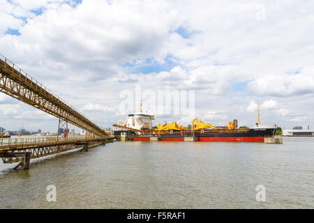 Das Frachtschiff Sand Fulmer Verschiebung seiner Ladung von Aggregat, während in der Themse angedockt. Stockfoto